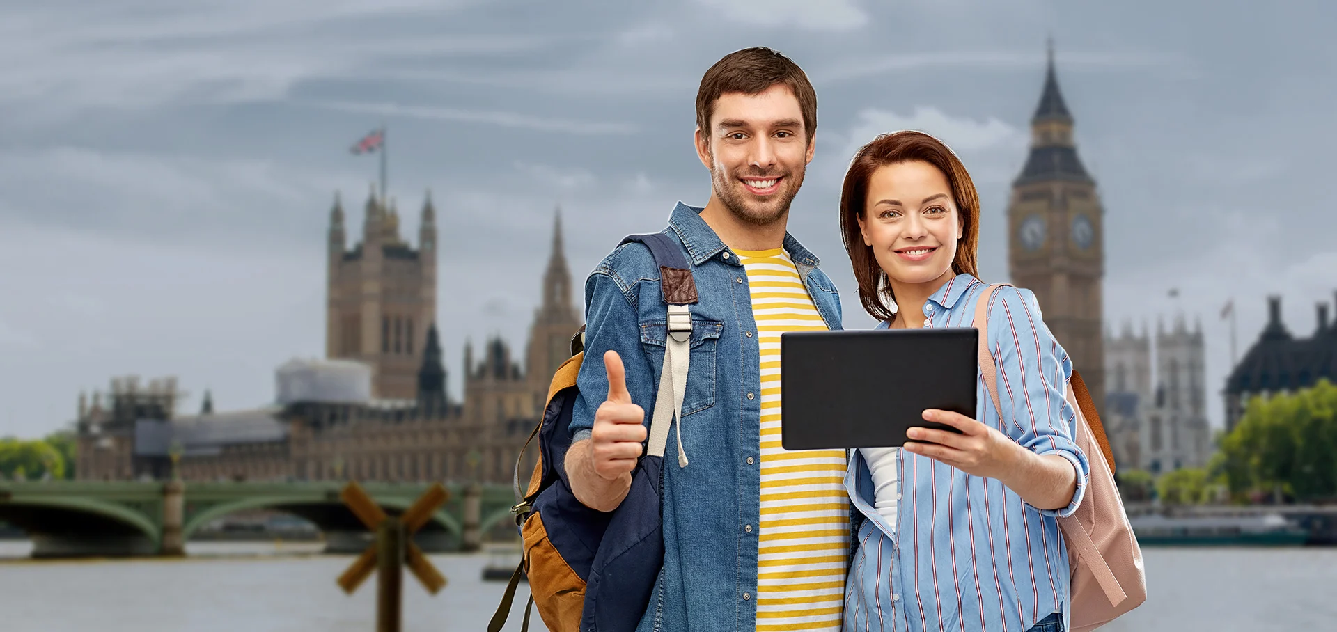 Young couple traveling overseas with backpacks and tablet in London